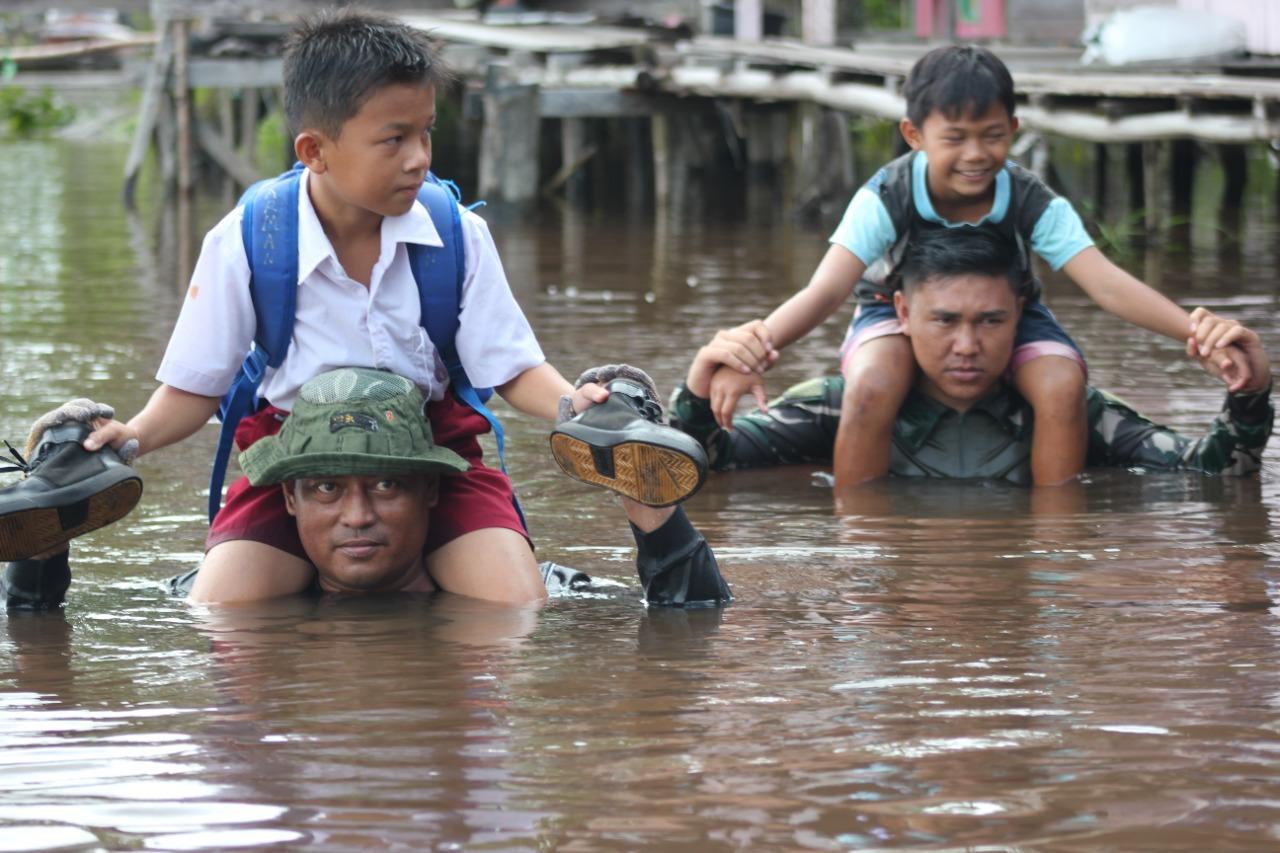 Anggota TNI Rela Terjang Banjir Kedalaman Seleher Demi Anak Sekolah